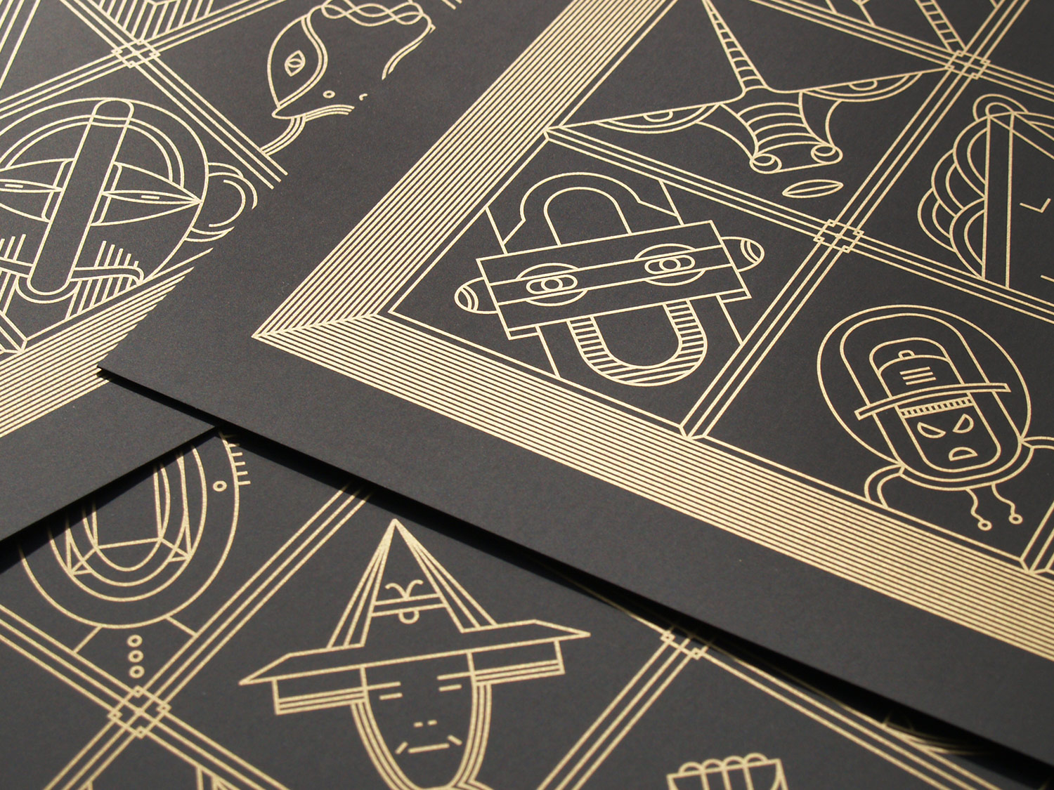 Overlapping black cards with gold geometric figures