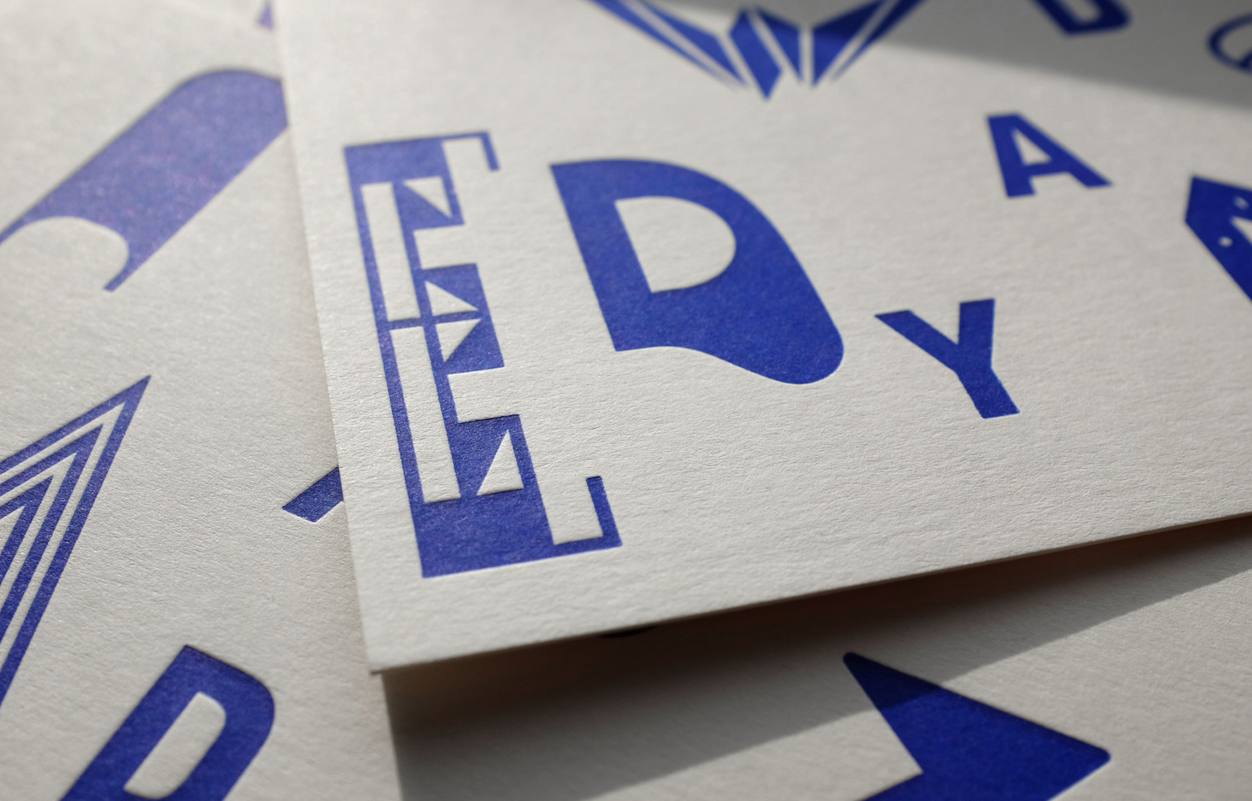 Close-up of a printed card with blue letters and geometric glyphs