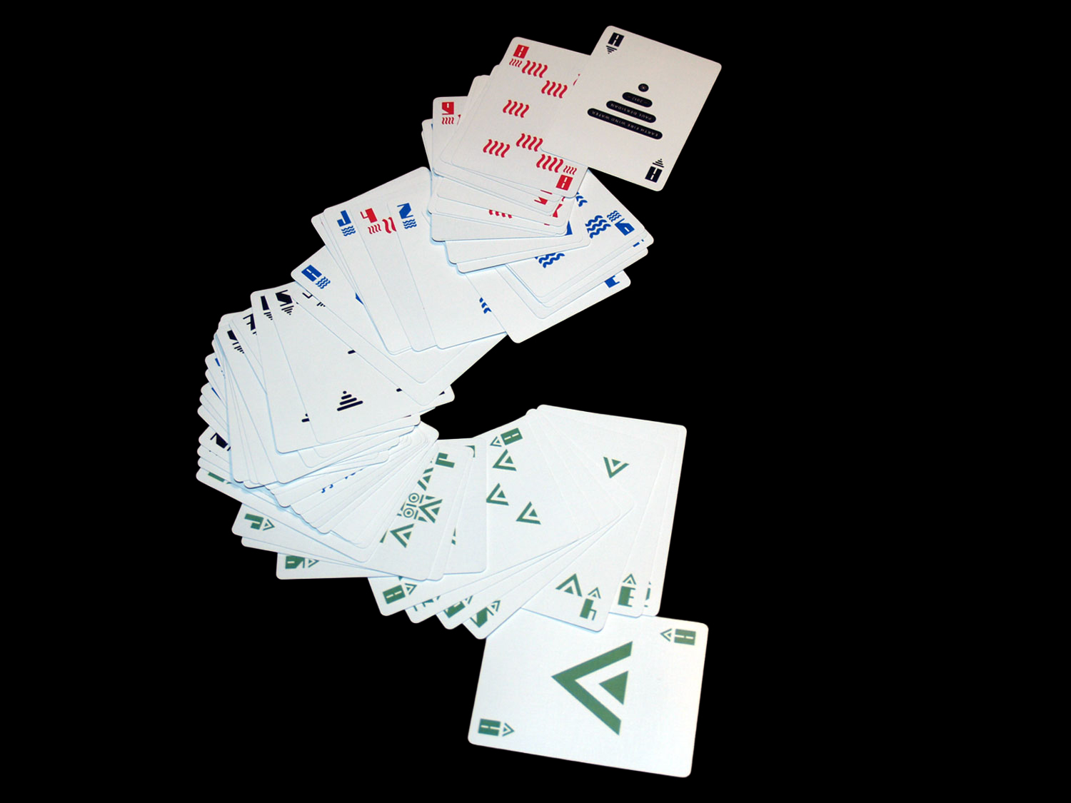 Long fan of green, red, blue and black geometric playing cards on black