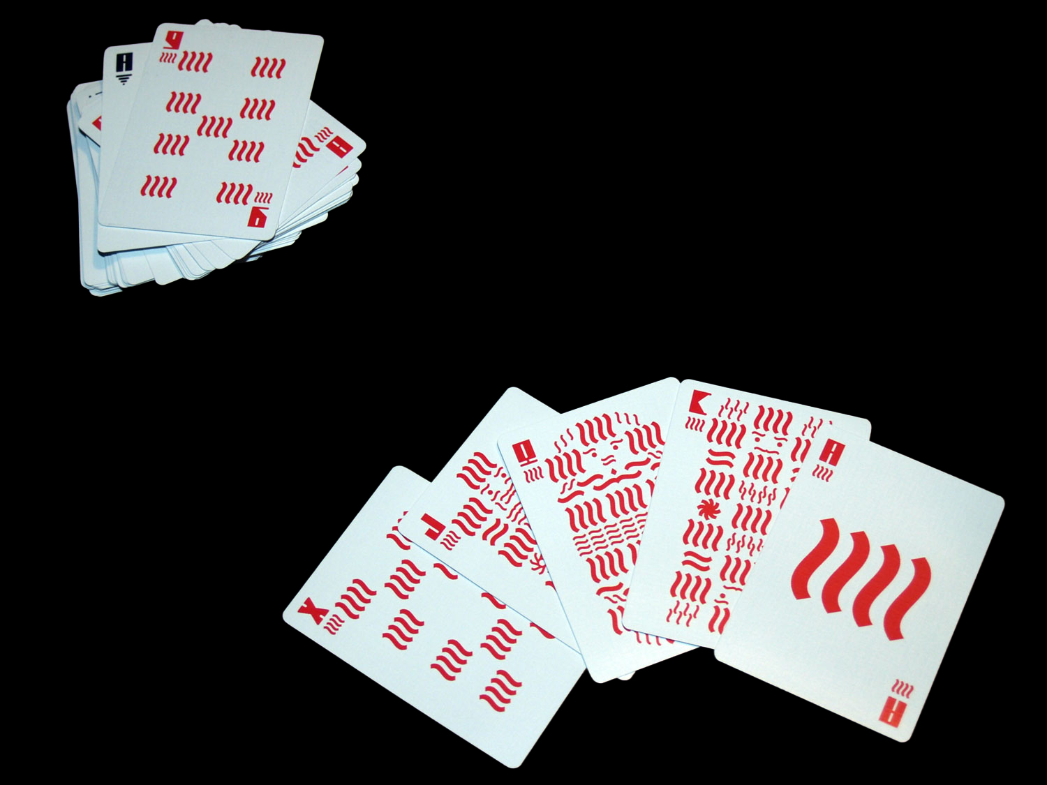 Small stacks and fan of red, blue and black geometric playing cards