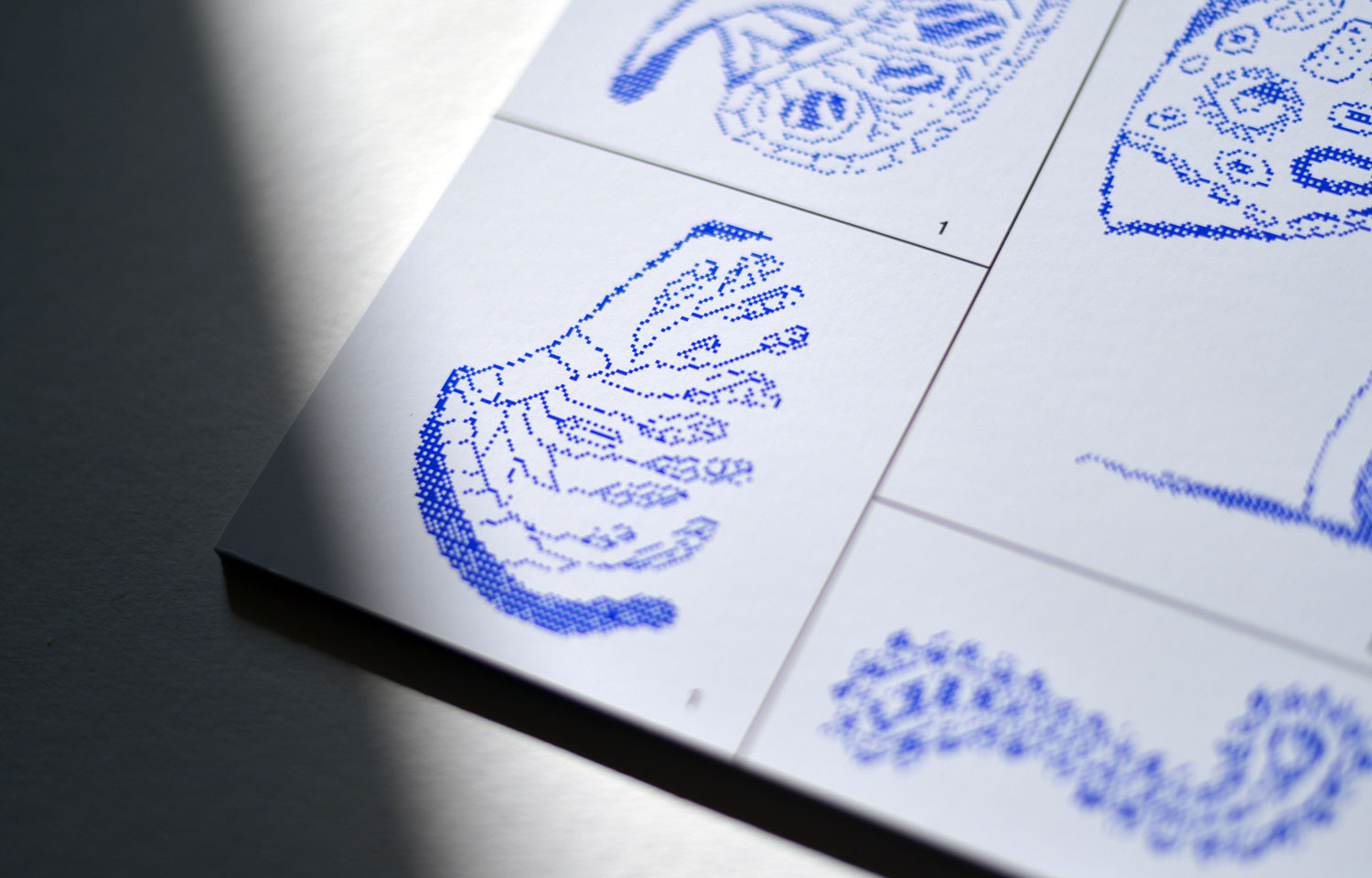 Close-up of blue dotted organic illustrations on a white gridded sheet