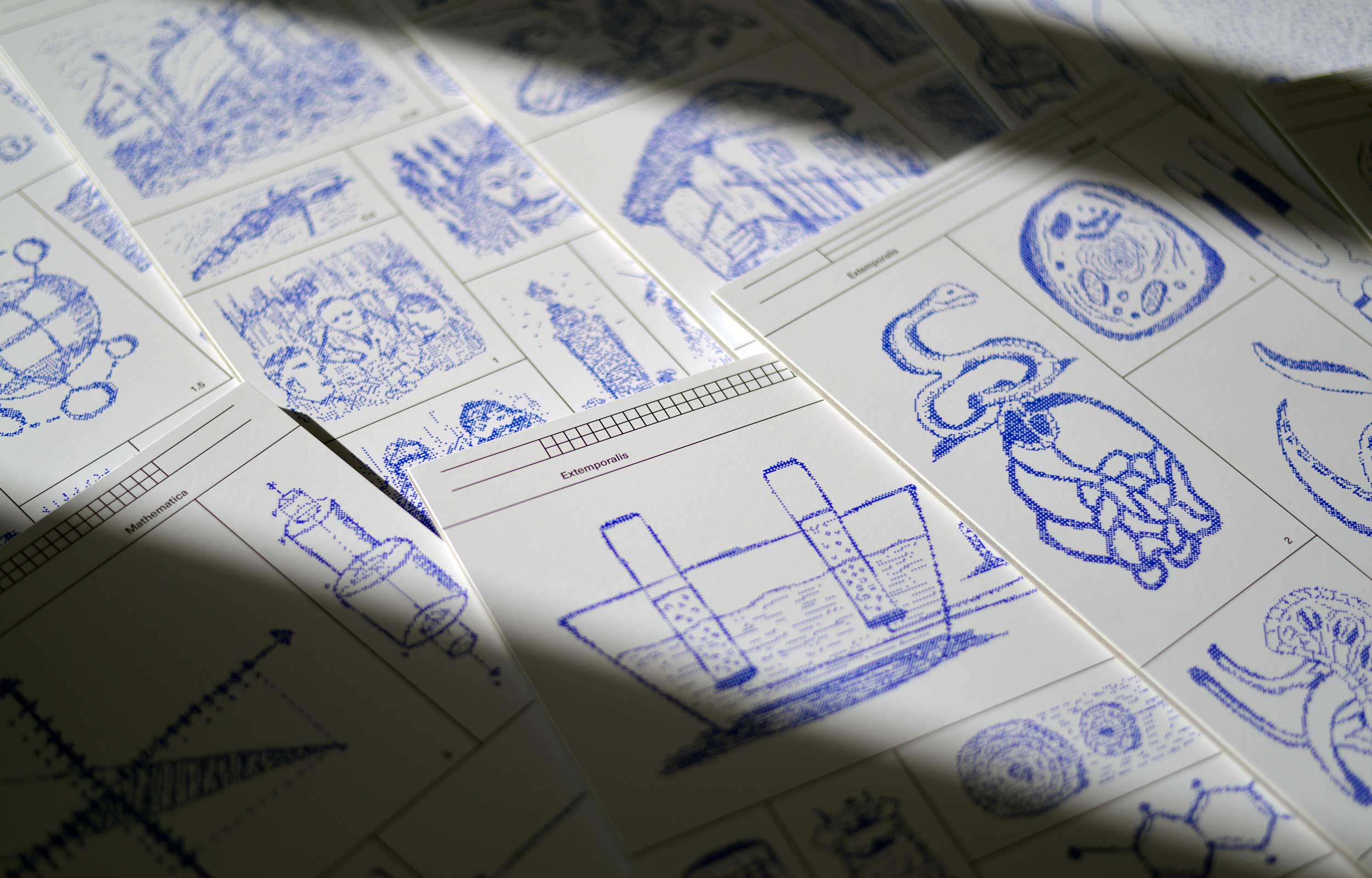 Overlapping white sheets printed with blue dotted scientific and pictorial diagrams