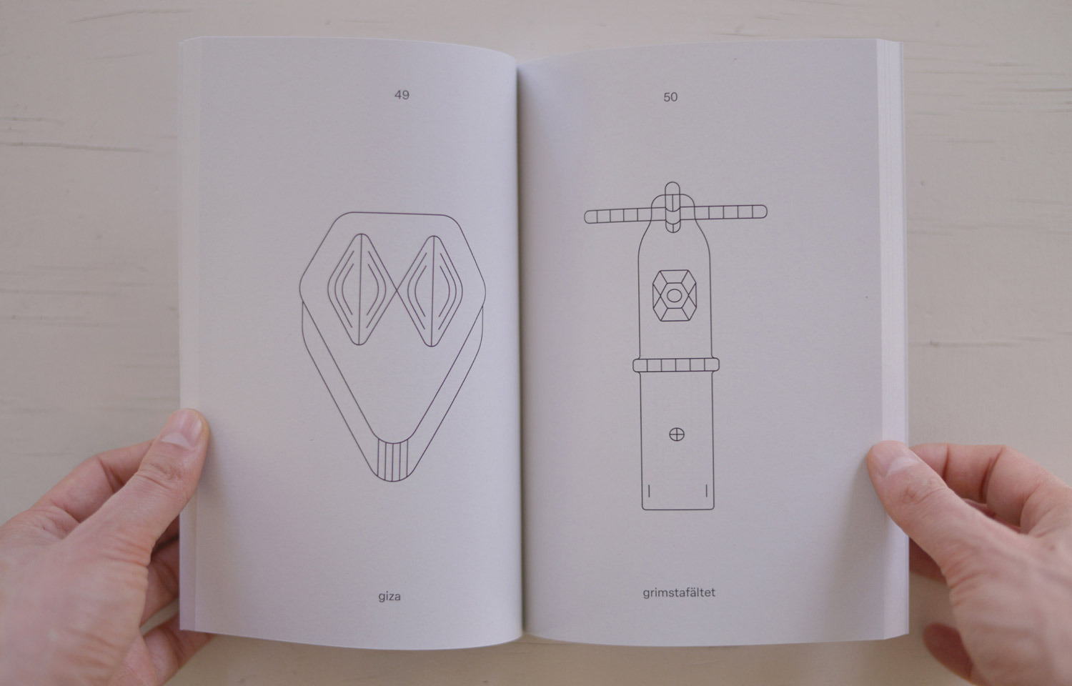 Open book spread with two fine-line abstract figures with face-like details
