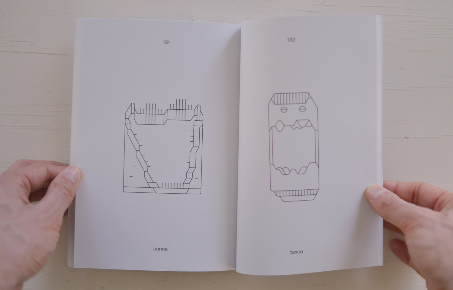 Open book spread with two fine-line geometric face drawings