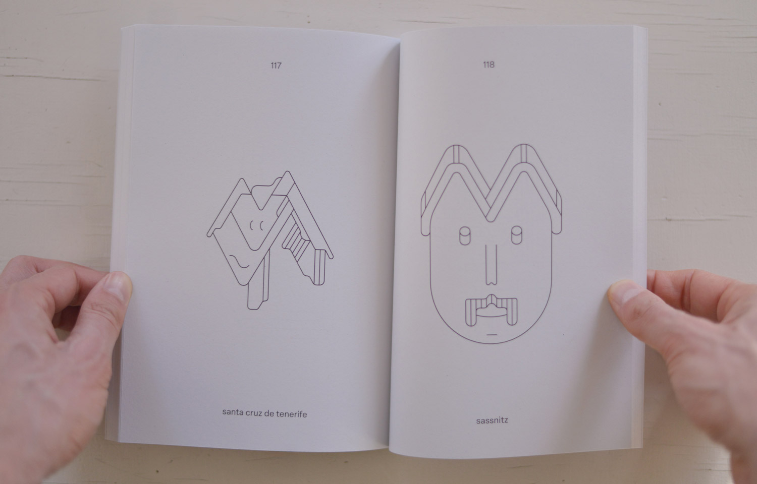 Open book spread with two angular line-drawn face figures