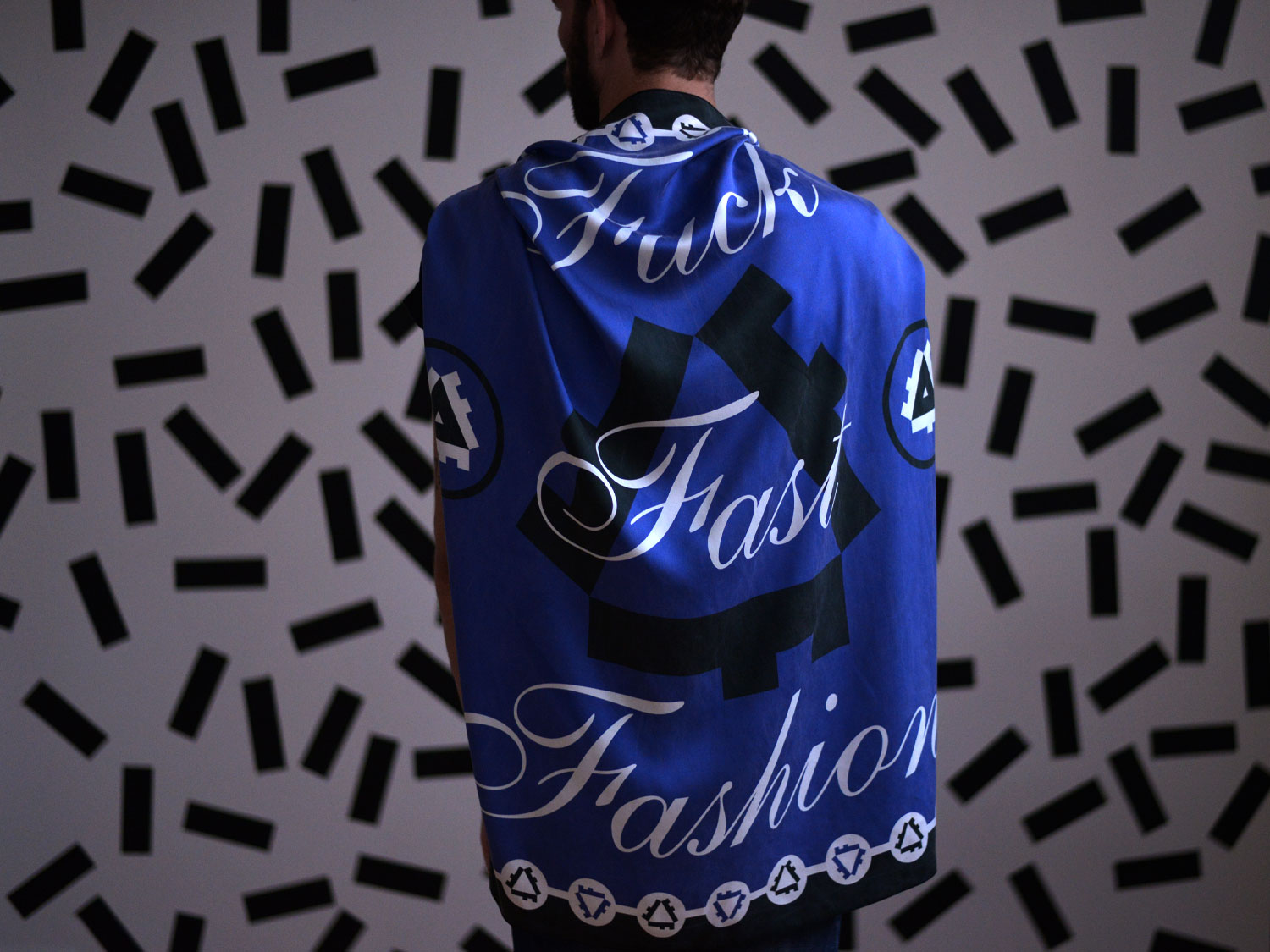Person wearing the blue Fuck Fast Fashion scarf across their back