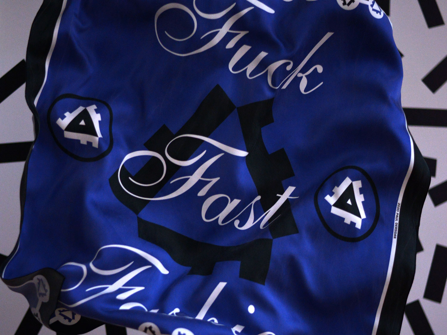 Close-up of the blue scarf printed with white script and black textile icon