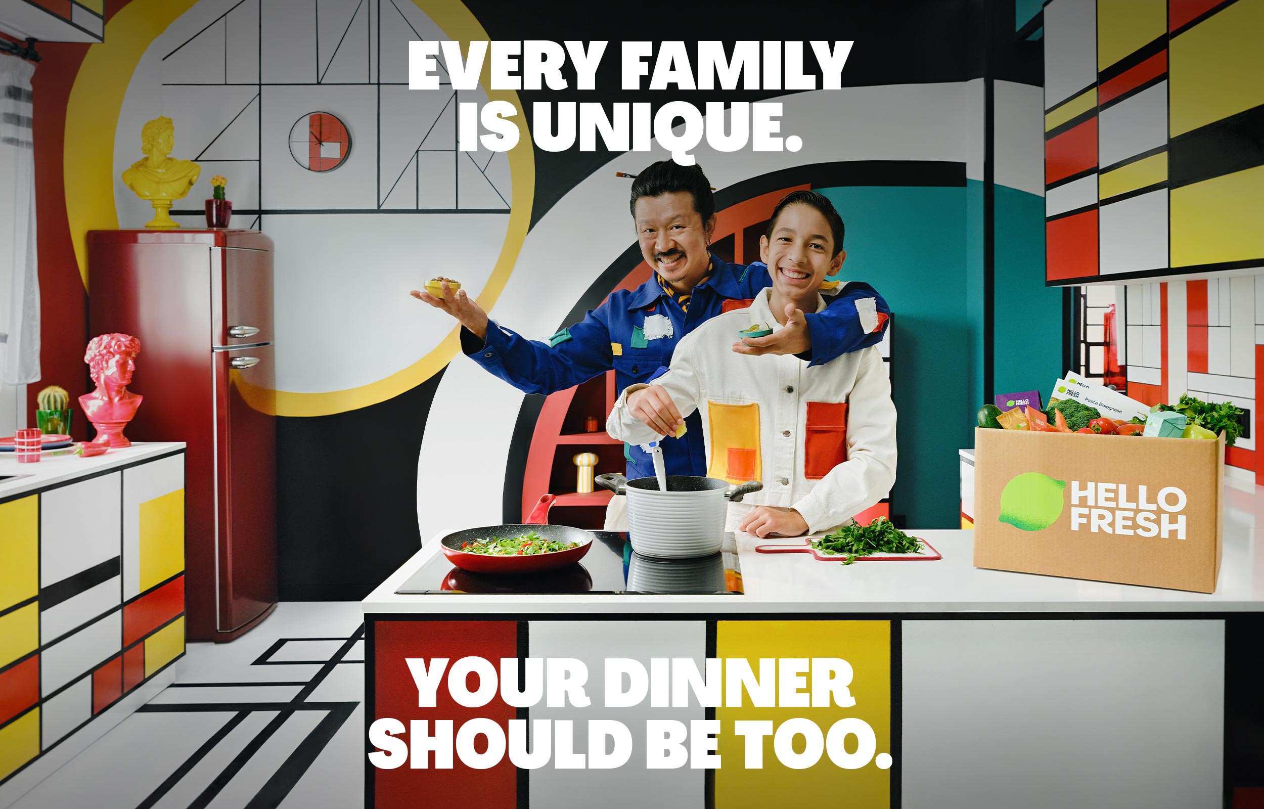 Two people preparing food in a colourful geometric kitchen beside a HelloFresh box