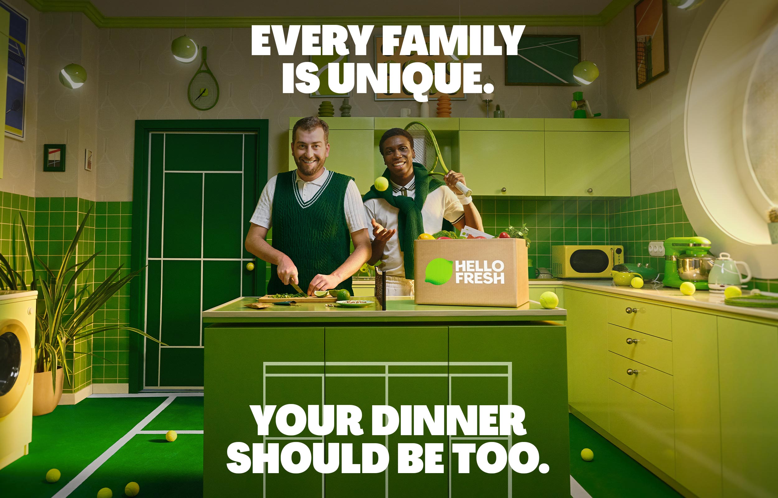 Two people cooking in a bright green kitchen beside a HelloFresh box