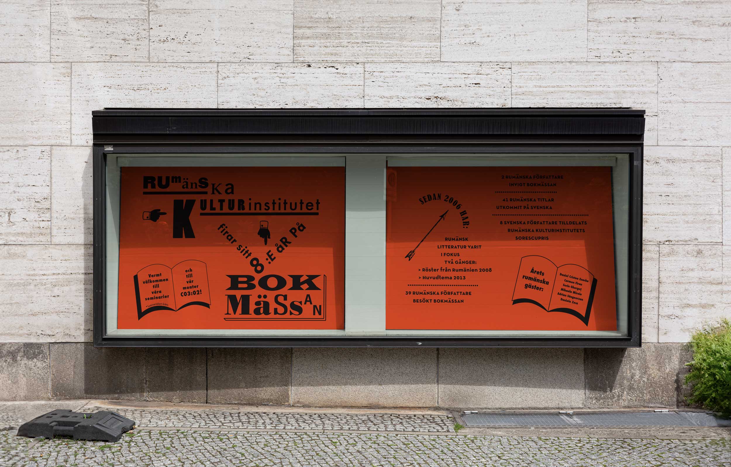 Two orange book fair posters displayed in an outdoor glass case