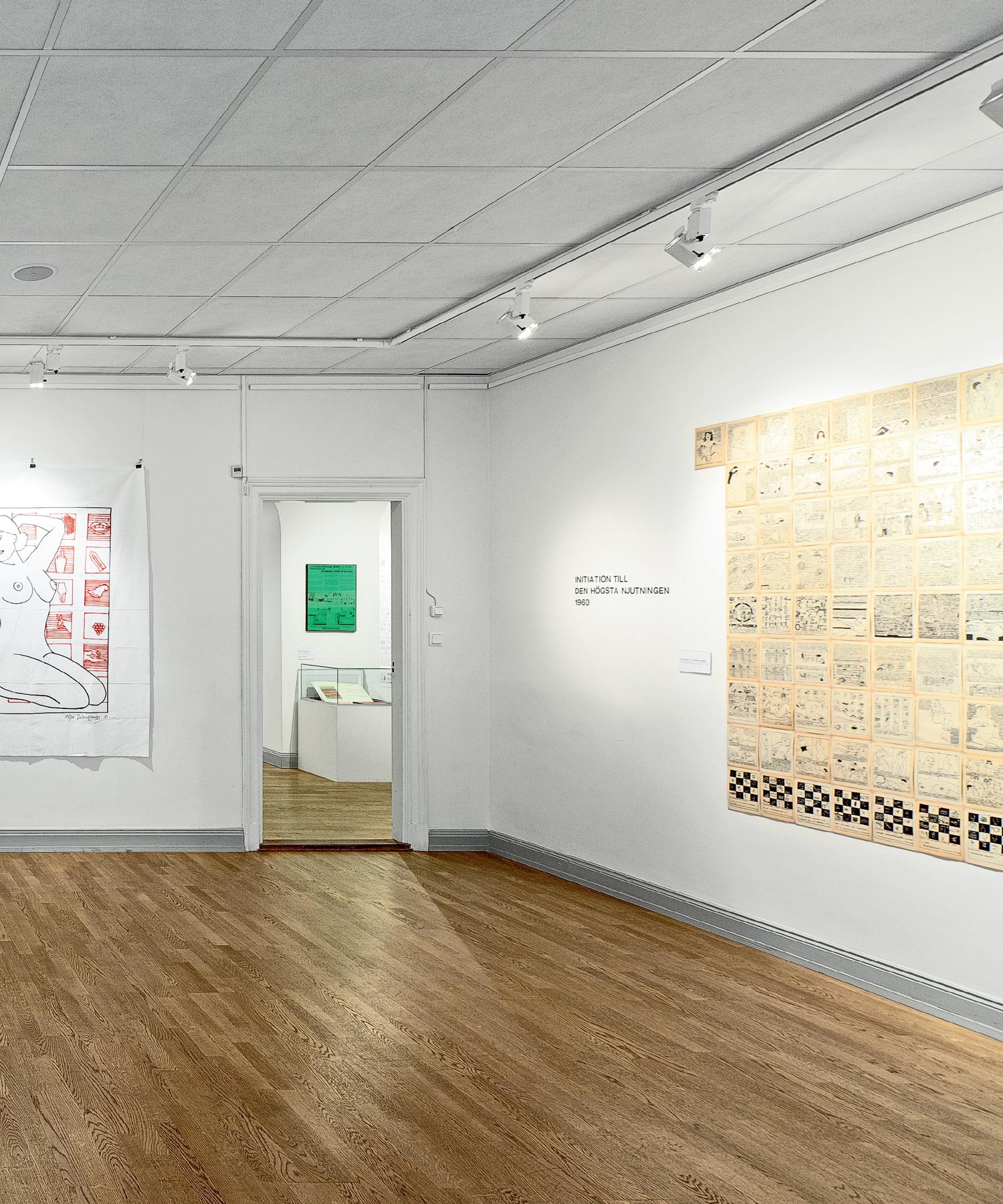 Bright gallery room with framed graphic works and a large beige wall installation