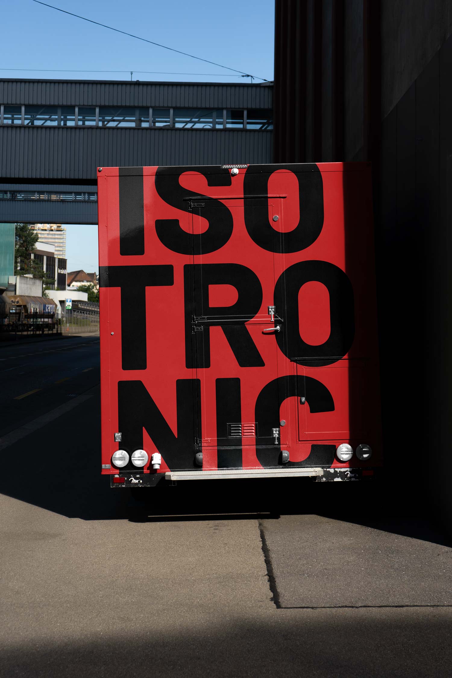 Red Isotronic branded truck parked on an industrial street
