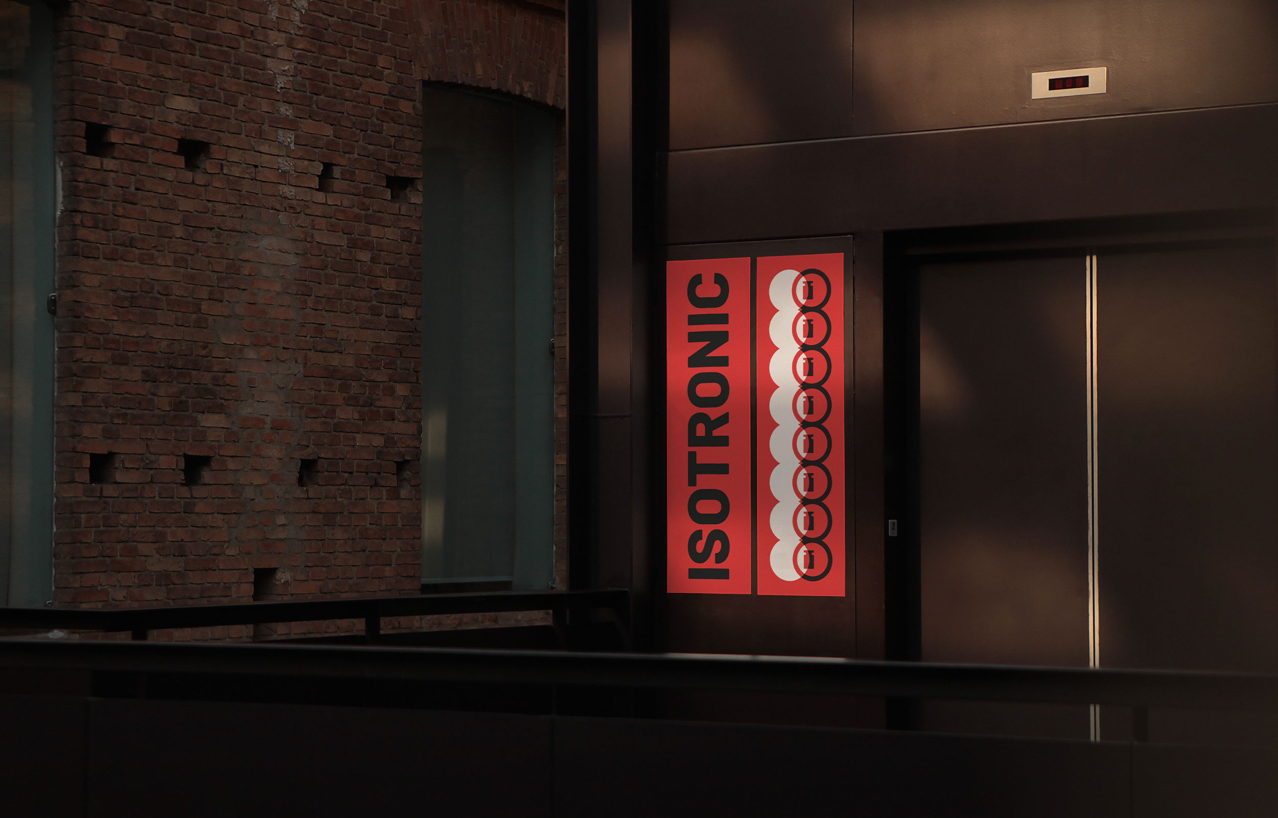 Red vertical Isotronic sign in a dark building entrance