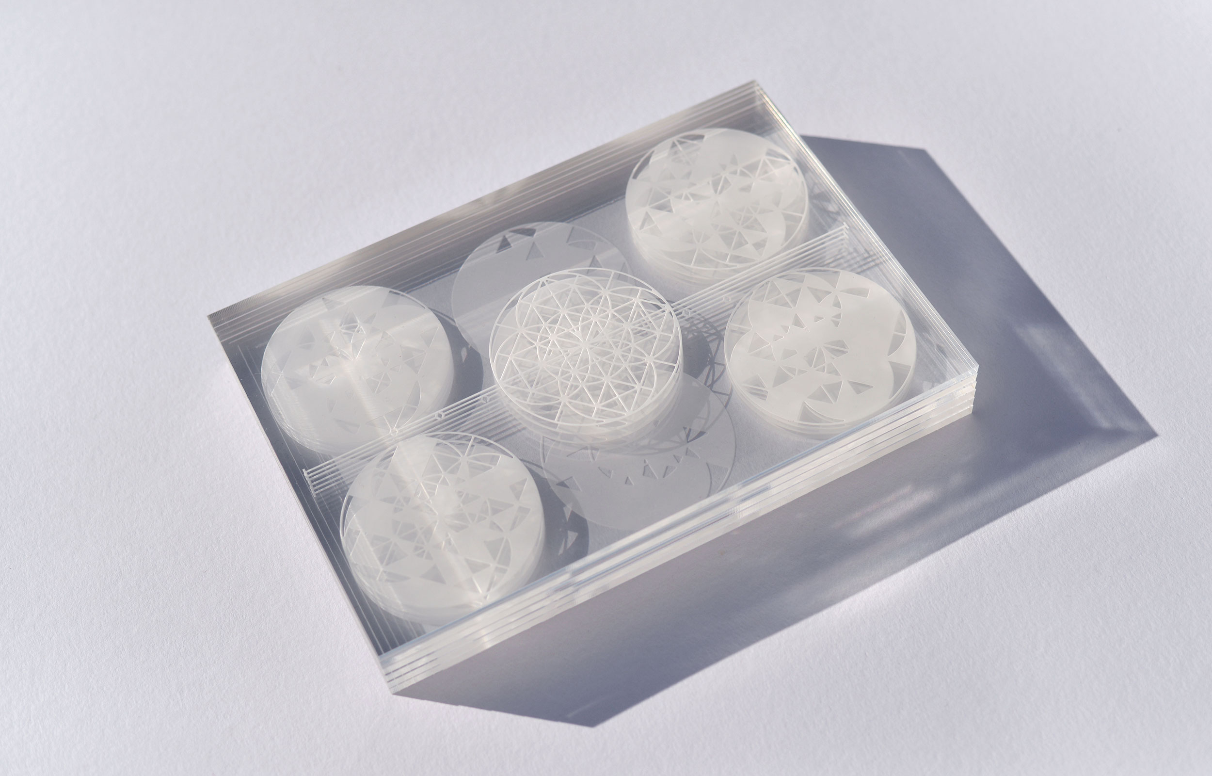 Frosted case containing circular geometric discs viewed from above