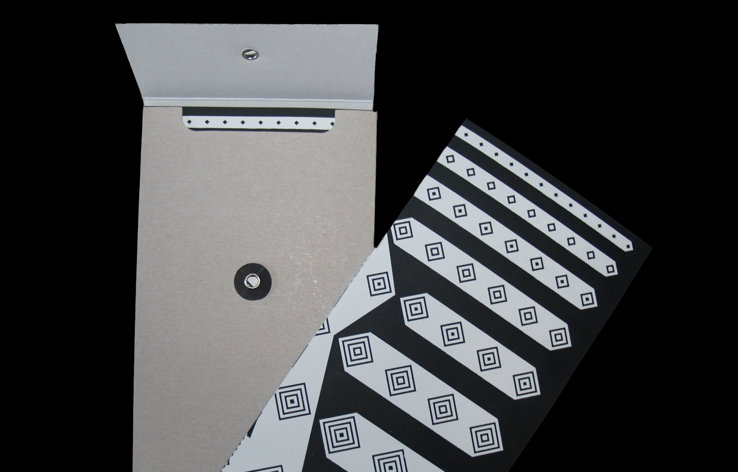 Photograph of folded printed paper pieces with black diamond motifs