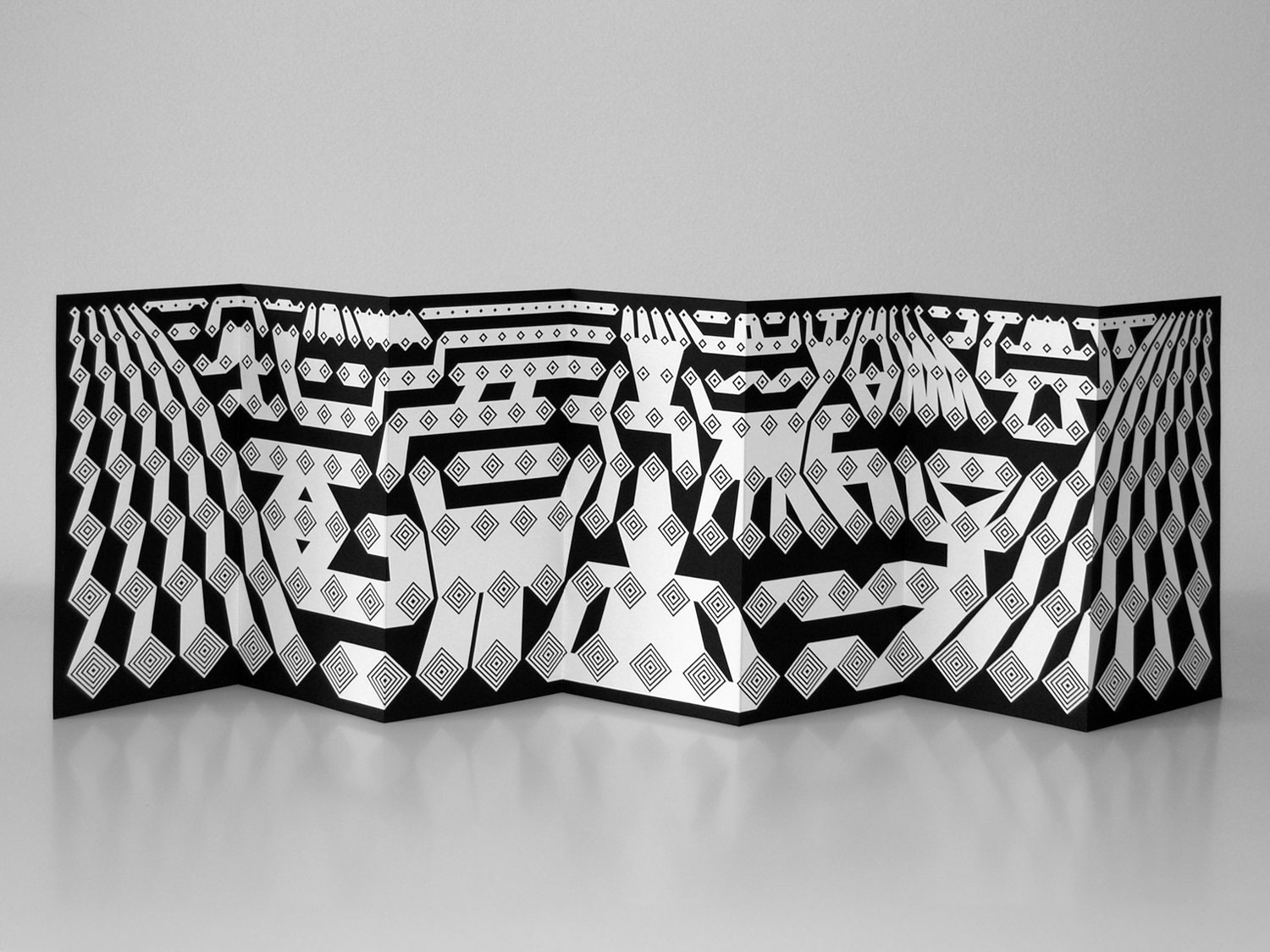 Wide black-and-white geometric banner displayed on a white wall