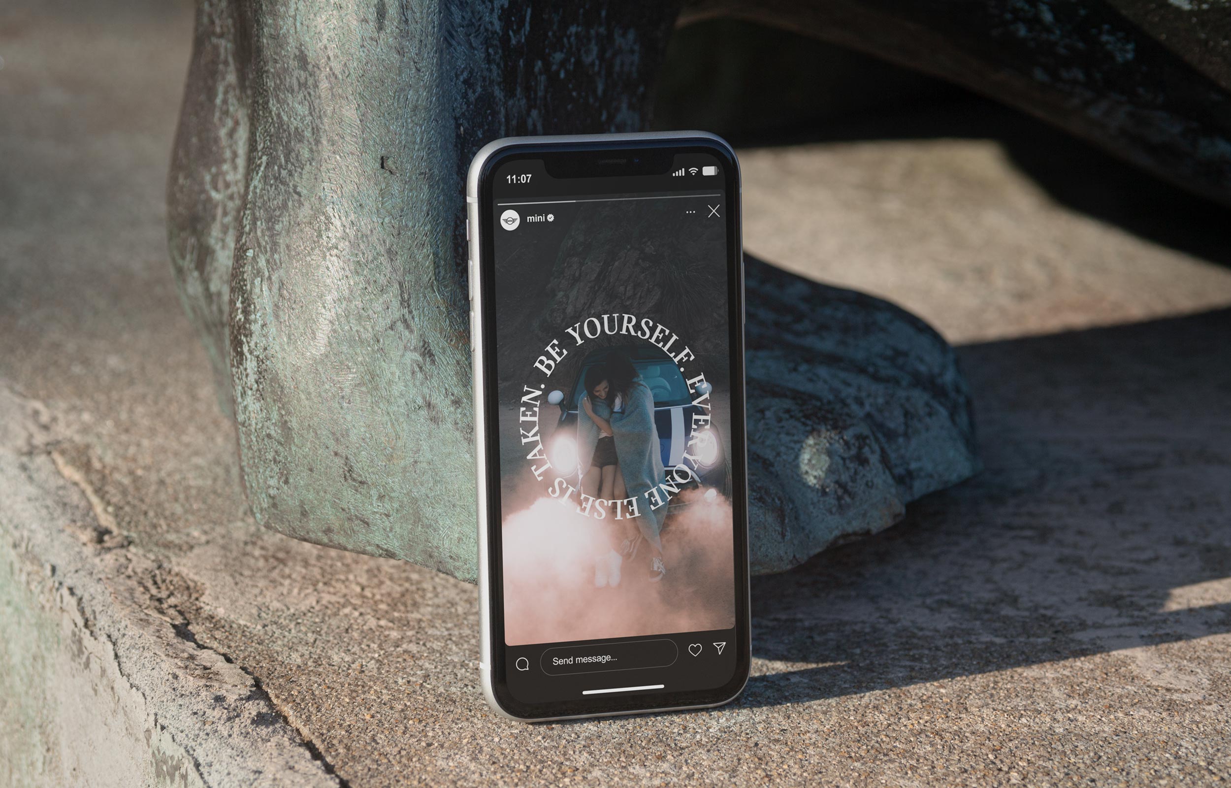 Smartphone displaying a Mini campaign page propped against rocks