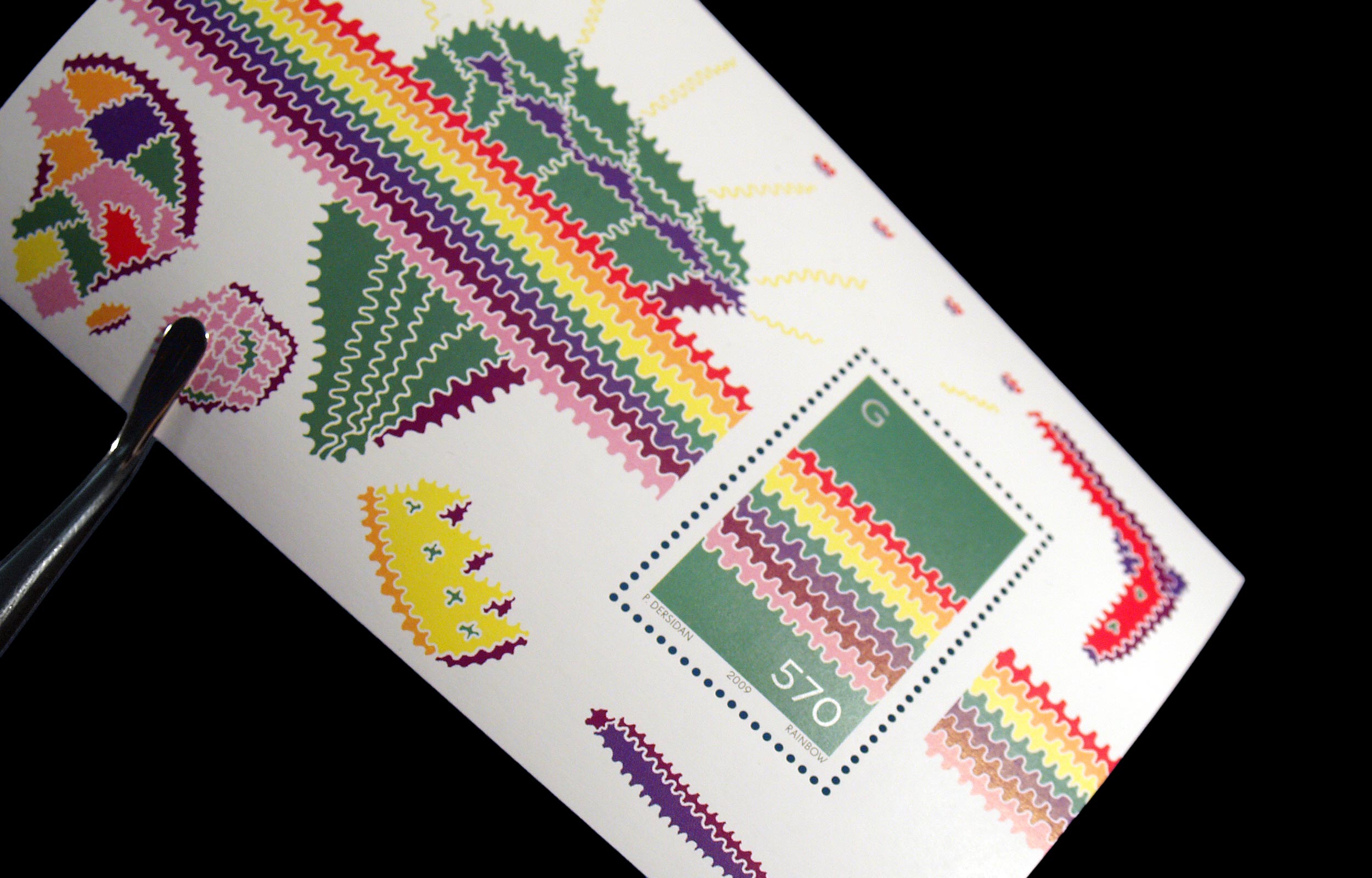 Close-up photograph of a rainbow-striped illustrated postcard