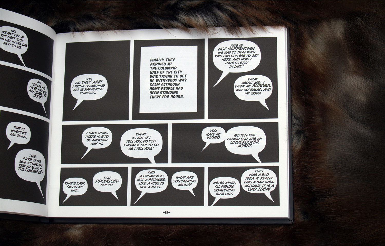 Open book spread of black comic panels filled with white speech balloons