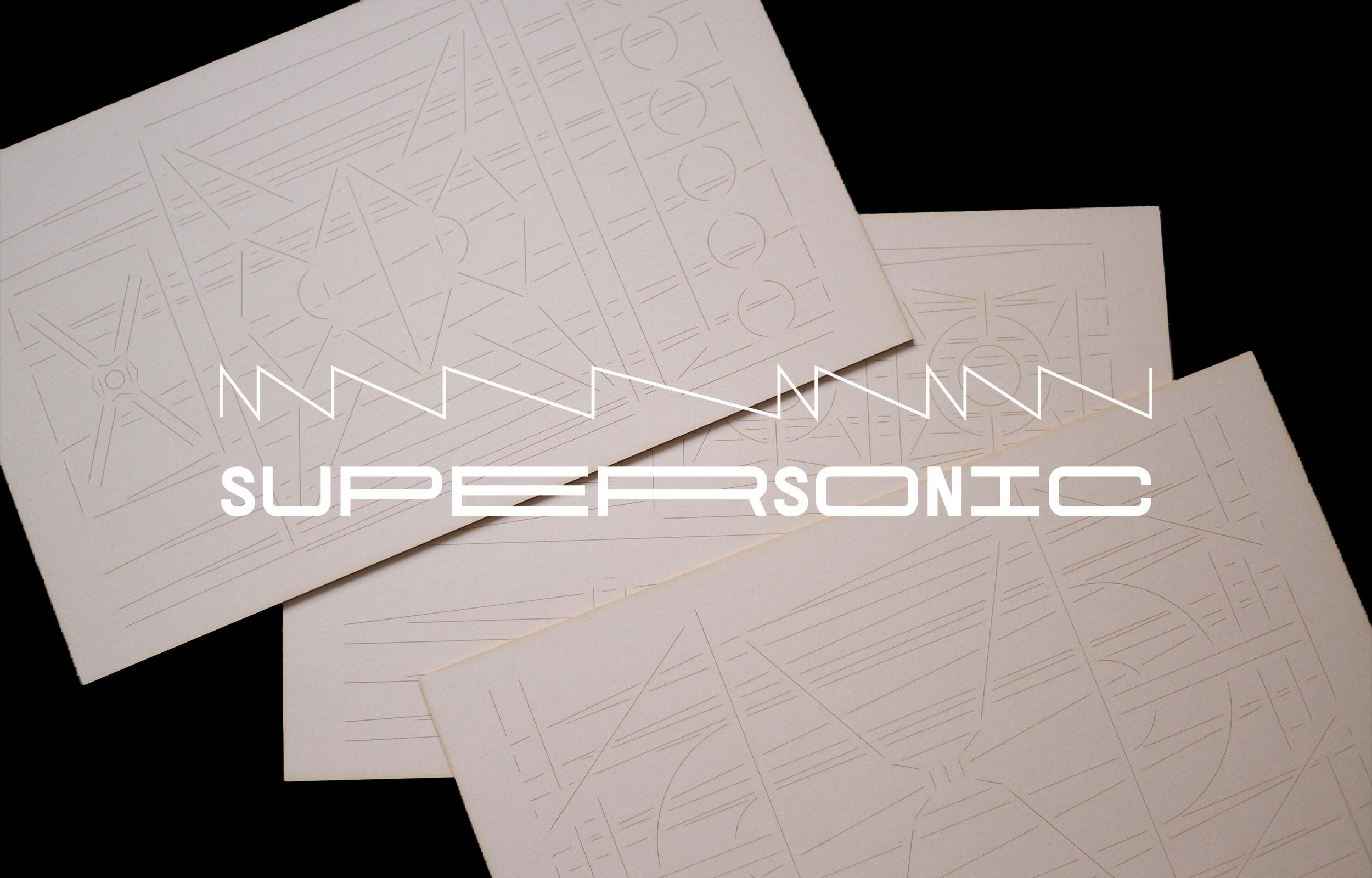 Overlapping pale cards embossed with linear geometric designs and the word Supersonic