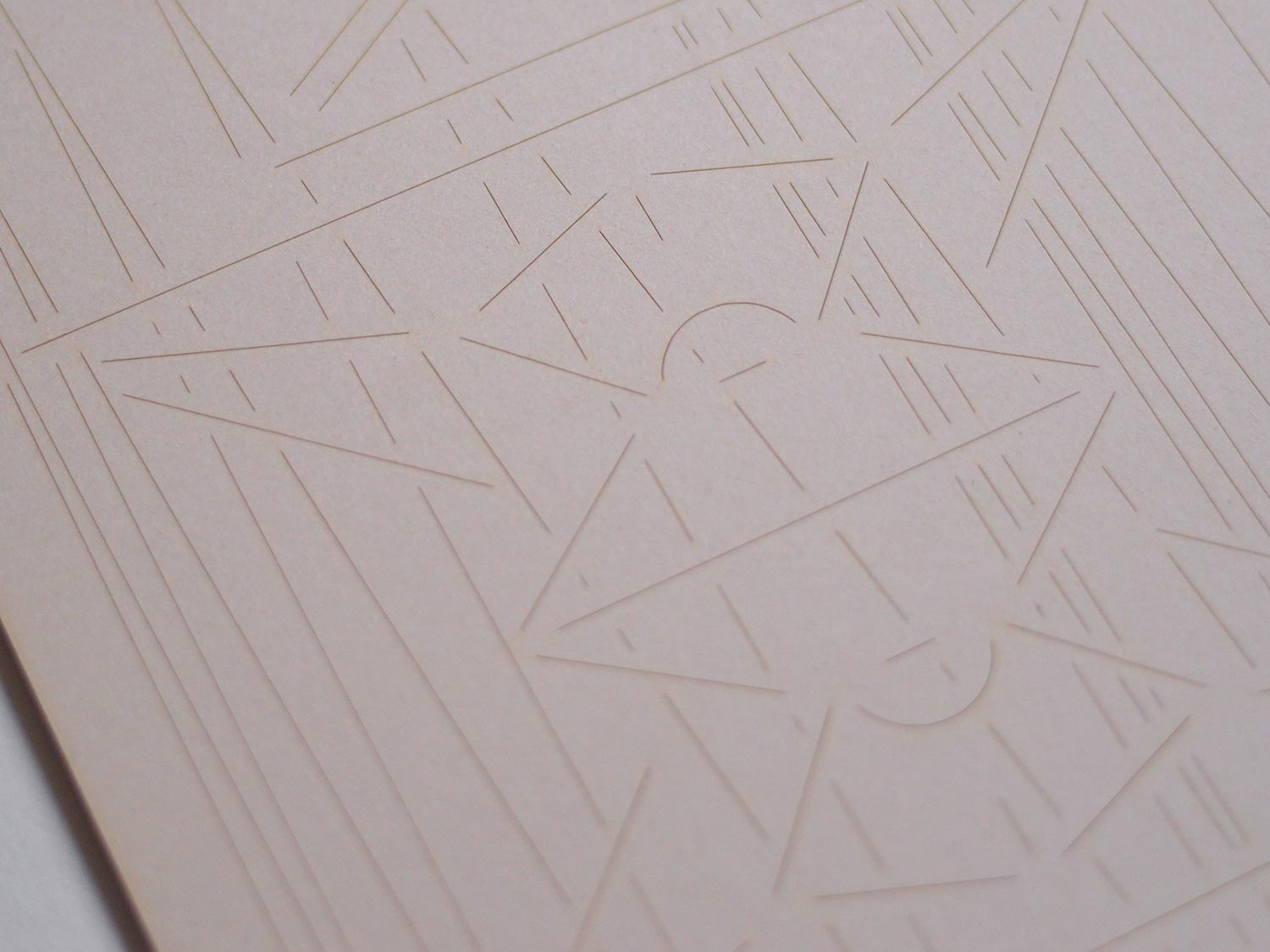 Close-up of pale embossed card with a circular geometric line design