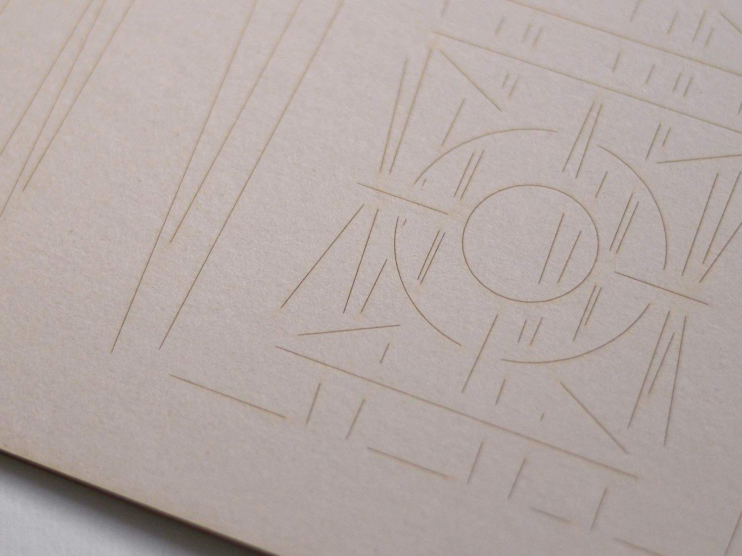 Close-up of pale embossed card with circle and radiating linear motif