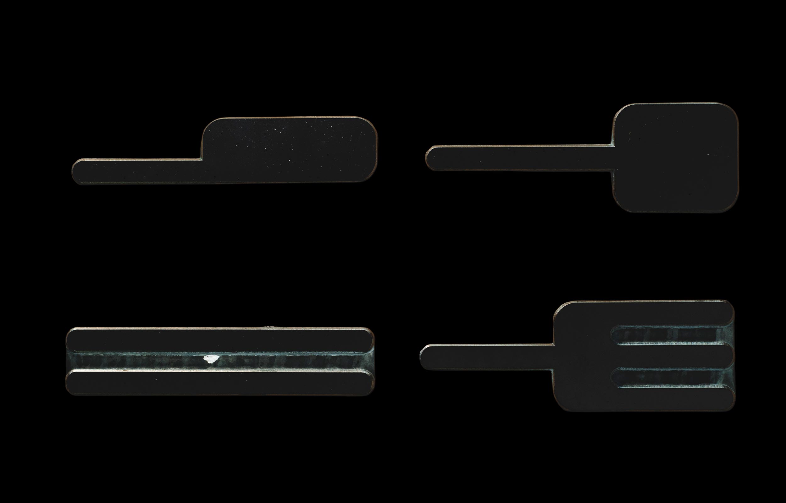 Four dark fork-shaped objects arranged on a black background