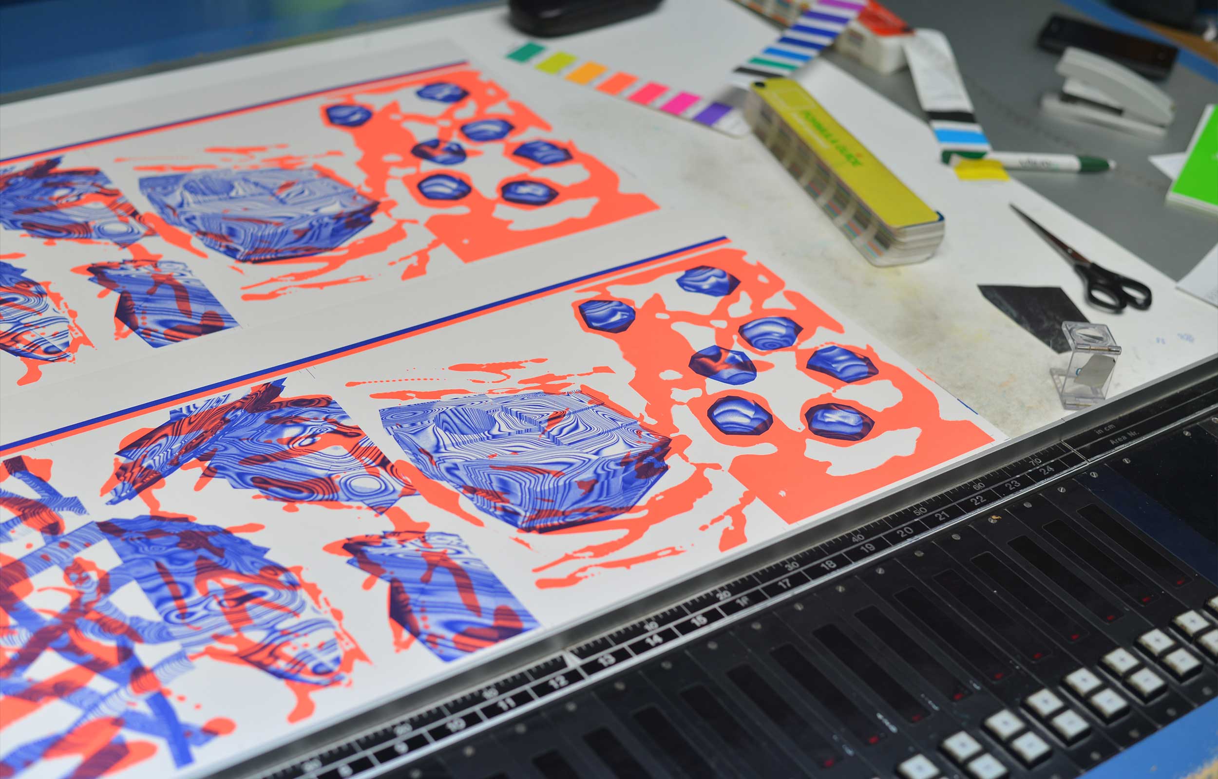 Red and blue printed sheets laid out on a printing press bed