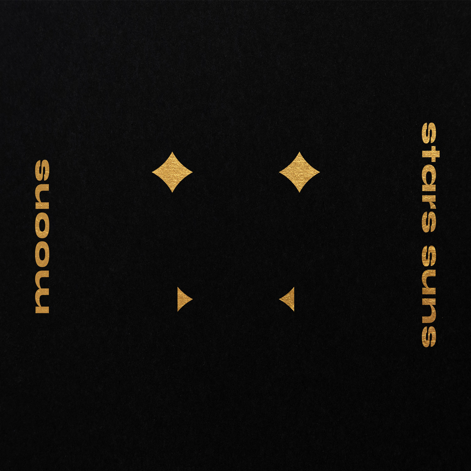 Four small gold diamond and triangle marks with Moons Stars Suns lettering on black