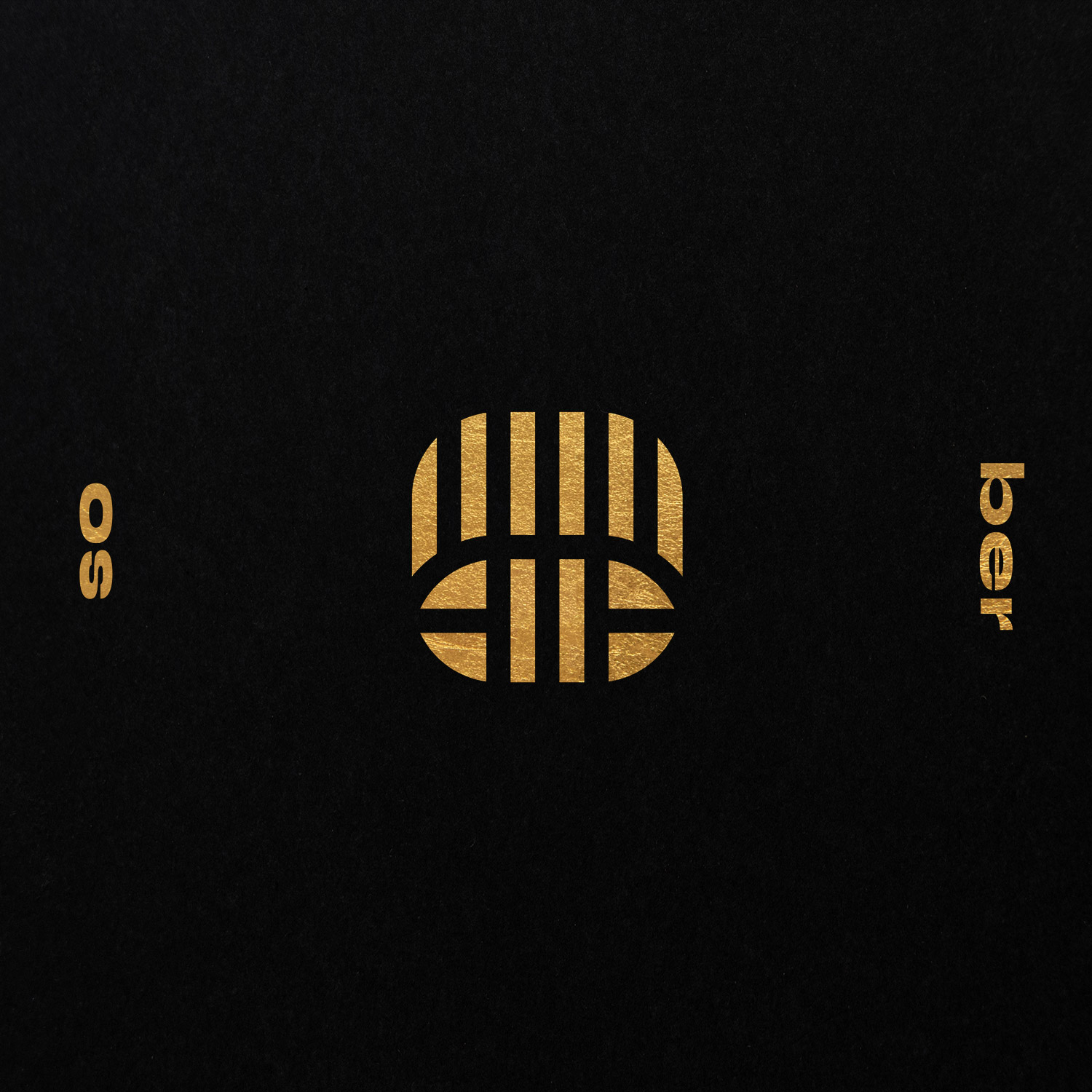 Gold striped circular emblem with So Be lettering on black